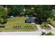 Aerial view showcases a large lot with a home, outbuildings, mature trees, and a white picket fence at 1413 Lithia Pinecrest Rd, Brandon, FL 33511