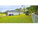 Spacious backyard with lawn, partially fenced in, featuring an outbuilding, mature trees and landscaping at 1413 Lithia Pinecrest Rd, Brandon, FL 33511