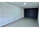 Spacious garage with smooth concrete floor, white brick walls, and a dark accent wall with a door at 1413 Lithia Pinecrest Rd, Brandon, FL 33511