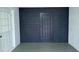 Bright and spacious garage with two doors, contrasting the white and dark blue brick walls at 1413 Lithia Pinecrest Rd, Brandon, FL 33511