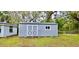 A gray outbuilding with double doors and a small window, suitable for storage or a hobby space at 1413 Lithia Pinecrest Rd, Brandon, FL 33511