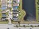 Aerial view of a home with solar panels adjacent to a pond, providing a sense of the property's location at 14454 Barley Field Dr, Wimauma, FL 33598