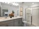Sleek bathroom with double vanity, modern fixtures, framed art, and a glass-enclosed shower at 15120 Cuzcorro Ct, Nokomis, FL 34275