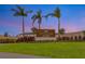 Community entrance sign for Vinterra Townhomes, framed by palm trees against twilight sky at 15120 Cuzcorro Ct, Nokomis, FL 34275
