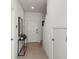 Inviting hallway featuring tile flooring, white walls, and a console table with a plant at 15120 Cuzcorro Ct, Nokomis, FL 34275