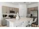 Well-lit kitchen with stainless steel appliances, island with barstool seating, and ample counter space at 15120 Cuzcorro Ct, Nokomis, FL 34275