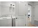 Convenient laundry room with modern washer and dryer, plus ample storage space at 15120 Cuzcorro Ct, Nokomis, FL 34275