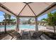 Secluded pool cabana offering a serene view of the community pool and surrounding tropical landscaping at 15120 Cuzcorro Ct, Nokomis, FL 34275