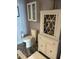 Classic white bathroom with toilet, vanity with glass-door storage, and dark marble flooring at 1520 Gulf Blvd # Ph2, Clearwater Beach, FL 33767