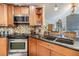 Modern kitchen with stainless steel appliances, granite countertops, mosaic tile backsplash, and ample wood cabinetry at 1905 Dove Field Pl, Brandon, FL 33510