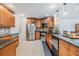 Modern kitchen with stainless steel appliances, granite countertops, mosaic tile backsplash and wood cabinetry at 1905 Dove Field Pl, Brandon, FL 33510