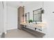 Bright bathroom featuring a double vanity with hanging pendant lights and two wooden framed mirrors at 1906 Carolina Ne Ave, St Petersburg, FL 33703