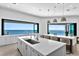 Large kitchen island with barstool seating, countertops, and folding glass doors opening to ocean views at 1906 Carolina Ne Ave, St Petersburg, FL 33703