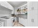 Clean laundry room featuring white cabinets, mosaic backsplash, and modern washer and dryer at 1906 Carolina Ne Ave, St Petersburg, FL 33703