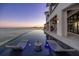 Relaxing infinity pool with lounge chairs overlooking the serene waterfront and city views at 1906 Carolina Ne Ave, St Petersburg, FL 33703