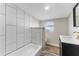 Bathroom featuring a tub/shower combination with modern tile, vanity, and rustic wood-look flooring at 1941 48Th S St, St Petersburg, FL 33711