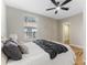 Bright bedroom featuring a ceiling fan, wood floors, and a cozy bed with decorative pillows and throw blanket at 1941 48Th S St, St Petersburg, FL 33711