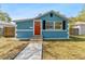 Charming blue bungalow with a bright orange front door and manicured landscaping at 1941 48Th S St, St Petersburg, FL 33711