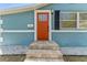 Charming front entrance with an orange door, stone steps, and a light-blue painted exterior at 1941 48Th S St, St Petersburg, FL 33711