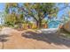 Detached garage with blue doors and gravel driveway, adjacent to a spacious yard with a large tree at 1941 48Th S St, St Petersburg, FL 33711