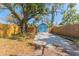 Detached garage with blue doors and a fresh gravel driveway, surrounded by a wood fence and large tree at 1941 48Th S St, St Petersburg, FL 33711