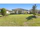 Well-maintained backyard with green lawn, covered patio, mature trees, and neighboring homes at 20173 Umbria Hill Dr, Tampa, FL 33647