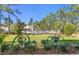 Green backyard with green grass, mature trees, and a white fence at 20173 Umbria Hill Dr, Tampa, FL 33647