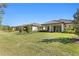 Well-maintained backyard with green lawn, mature trees, and neighboring homes in the distance at 20173 Umbria Hill Dr, Tampa, FL 33647