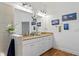 Bright bathroom featuring double sinks with granite counters, modern lighting, and wood-look flooring at 20173 Umbria Hill Dr, Tampa, FL 33647