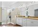 Bright bathroom featuring double sinks with granite counters, a glass enclosed shower, and wood-look flooring at 20173 Umbria Hill Dr, Tampa, FL 33647