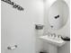 Clean half-bath with a pedestal sink, modern fixtures, and decorative accents on the wall at 20173 Umbria Hill Dr, Tampa, FL 33647