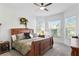 Inviting bedroom with a wooden bed frame, ceiling fan, and natural light from the bay windows at 20173 Umbria Hill Dr, Tampa, FL 33647