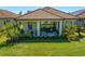 A covered patio with tile roof overlooks the manicured lawn and features comfortable seating at 20173 Umbria Hill Dr, Tampa, FL 33647