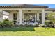 A covered patio featuring ceiling fans, comfortable seating, and manicured landscaping at 20173 Umbria Hill Dr, Tampa, FL 33647