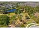 Scenic view of a pond surrounded by lush greenery, trees, and a fenced dog park at 20173 Umbria Hill Dr, Tampa, FL 33647