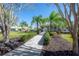 Beautifully landscaped walkway leading to the clubhouse entrance, framed by lush greenery and mature trees at 20319 Starfinder Way, Tampa, FL 33647