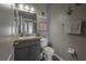Clean half bathroom with a gray vanity, tile floors, and a decorative mirror at 20319 Starfinder Way, Tampa, FL 33647
