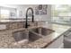 A double bowl kitchen sink features a granite countertop and modern black faucet at 20319 Starfinder Way, Tampa, FL 33647