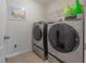 Laundry room with modern washer and dryer set, a shelf, and neutral colors at 20319 Starfinder Way, Tampa, FL 33647