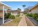 Landscaped condo exterior featuring green shrubs, pavers, and a walkway to the front door at 2260 Oak Neck Rd # B, Clearwater, FL 33763