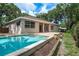 Rear exterior view showcases the sparkling pool, brick patio, and the home's neutral color palette at 2270 Barbara Dr, Clearwater, FL 33764