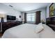 Bright bedroom with a king bed, work space, hardwood floors, and natural light at 2448 Enterprise Rd # 5, Clearwater, FL 33763