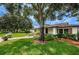 Well-maintained home exterior with lush lawn, brick accents, and mature trees in a peaceful setting at 2448 Enterprise Rd # 5, Clearwater, FL 33763