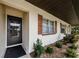 Exterior view of the home featuring charming landscaping, brick accents, and covered parking at 2448 Enterprise Rd # 5, Clearwater, FL 33763