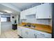 Bright kitchen featuring white cabinetry, wood countertops, and modern appliances at 2448 Enterprise Rd # 5, Clearwater, FL 33763