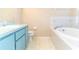 Bright bathroom featuring a vanity, toilet, and a soaking tub with tile surround at 26348 Crooked Tree Ln, Brooksville, FL 34602