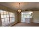 Bright dining room featuring a modern chandelier, a large window, and neutral wall paint at 26348 Crooked Tree Ln, Brooksville, FL 34602