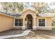 Charming front entrance with a covered porch, decorative columns, and a well-lit walkway at 26348 Crooked Tree Ln, Brooksville, FL 34602