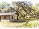 Property view featuring a barn, mature trees, and a residence in the distance at 26348 Crooked Tree Ln, Brooksville, FL 34602