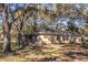 Rear view of the property featuring a screened-in porch and lots of surrounding foliage at 26348 Crooked Tree Ln, Brooksville, FL 34602